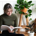 Colț de lectură liniștitor cu plantă și lumină naturală